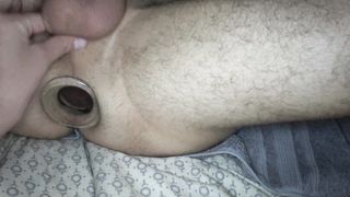 Two girls fist and stretch a guys ass with a tunnel plug and speculum