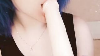 Girl with pink hair fucks herself with a black dildo.