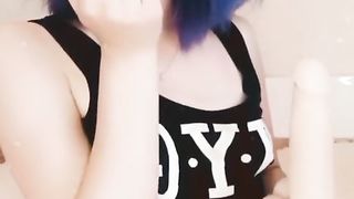 Girl with pink hair fucks herself with a black dildo.