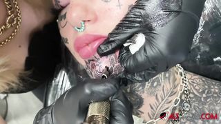 Gorgeous chick covered in tattoos gets another tattoo on her face